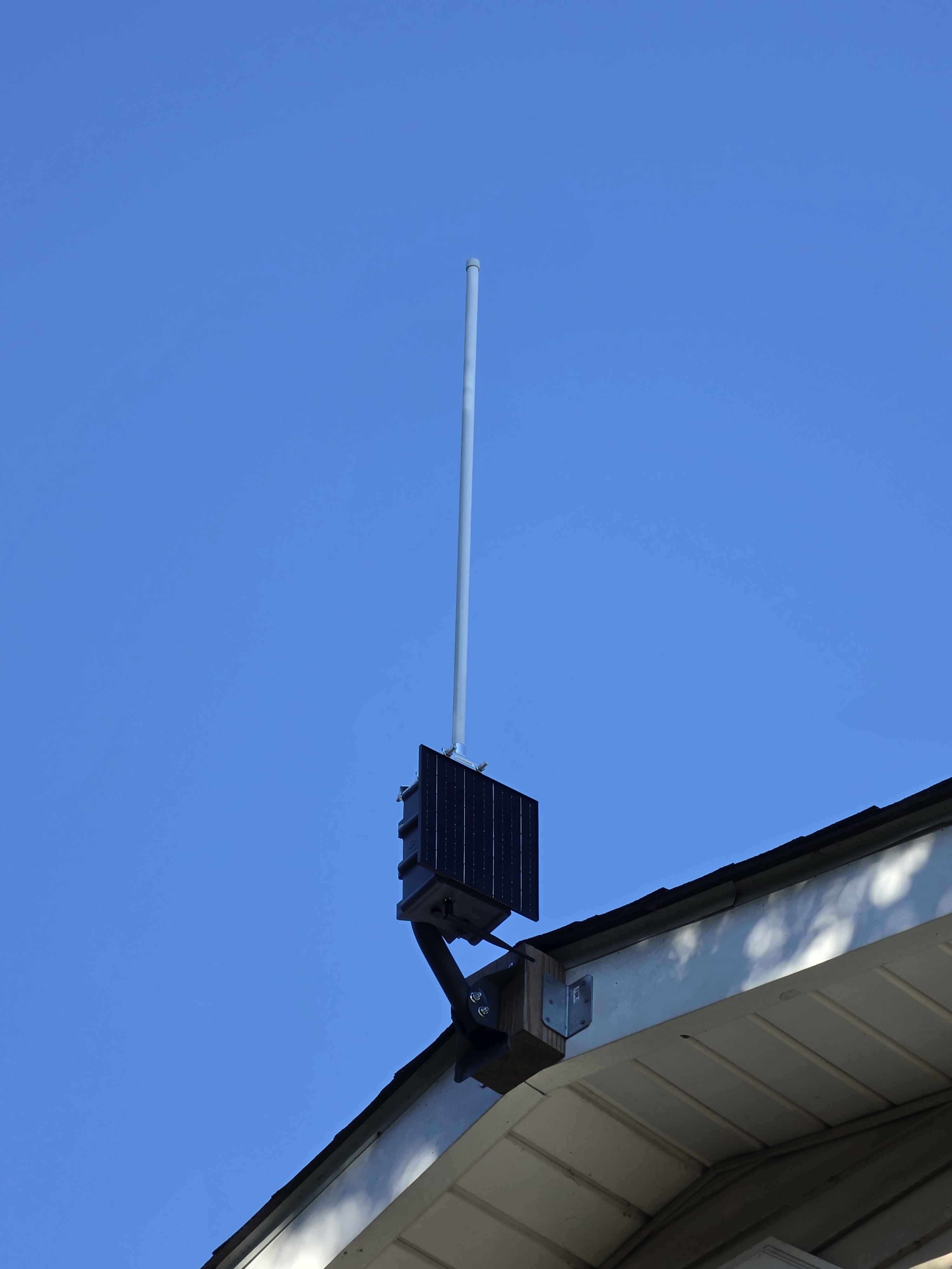 GrumpyMesh repeater and antenna mounted high on a rooftop